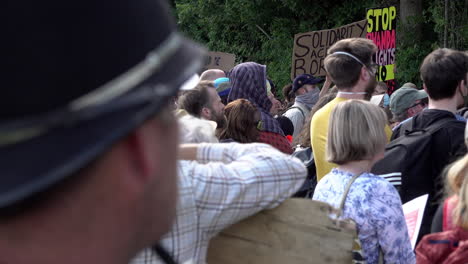 A-Police-liaison-officer-stands-watching-over-a-protest-opposing-deportation-flights-to-Rwanda-outside-Brook-House-Immigration-Removal-Centre-at-Gatwick-Airport