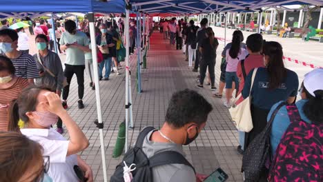 Residents-queue-in-line-to-receive-PCR-tests-for-coronavirus-from-a-Community-Testing-Centre-truck-to-tackle-the-spread-of-the-virus-and-a-pandemic-wave-near-Hong-Kong's-financial-district