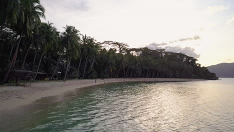 Vista-Aérea-De-La-Playa-Tropical-Por-La-Tarde-Sobre-Aguas-Claras-En-Filipinas---Cámara-De-Seguimiento-De-ángulo-Bajo