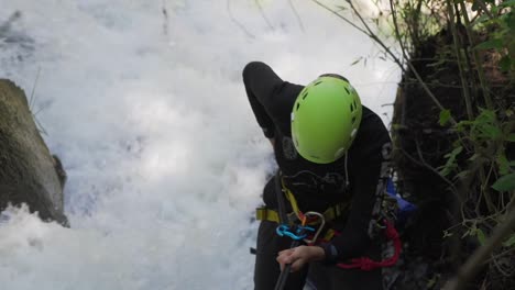 A-woman-rappeling-down-a-waterfall-you-can-see-the-forces-with-the-water-is-pouring-down