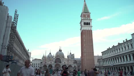 Primer-Plano-Del-Campanario-De-San-Marcos,-Con-Turistas-Disfrutando-De-La-Plaza-En-Venecia,-Italia.