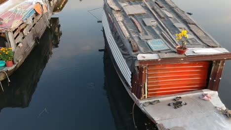 Drone-dolly-shot-across-three-small-traditional-riverboats