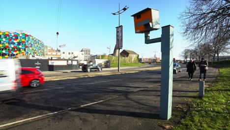 Cars-travel-past-a-speed-camera-in-Stoke-on-Trent,-slowing-down-as-they-pass-the-camera,-safe-driving