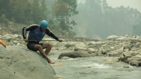 Ein-Trainer-Eines-Bergsteigerinstituts-Im-Himalaya-überquert-Den-Gebirgigen-Fluss-Mit-Einem-Seil-Und-übt,-Den-Fluss-Mit-Einem-Seil-Zu-überqueren