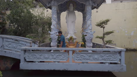 Foto-De-Un-Hombre-Después-De-Que-Termina-De-Rezar-Frente-A-Una-Hermosa-Estatua-Blanca-De-Buda-En-Un-Pabellón-De-Un-Templo-Budista