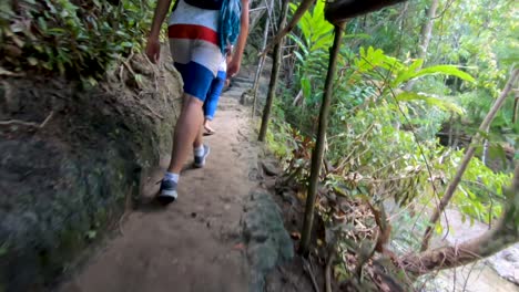 Un-Hombre-Caminando-Por-Un-Sendero-Y-Luego-Gira-Hacia-Una-Hermosa-Cascada-En-El-Entorno-De-La-Selva-Tropical-De-La-Isla-De-Bohol,-Filipinas