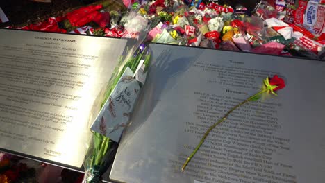 People-pay-their-respects-at-the-Gordon-Banks-statue-by-the-Stoke-City-stadium,-people-signing-shirts,-scarves,-flags-and-the-book-of-remembrance