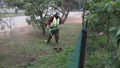 A-man-using-a-weed-eater-on-the-road-verge-in-a-rural-town