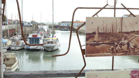 Vista-Del-Puerto-De-Saint-trojan-les-bain-En-La-Isla-De-Oléron-Con-Una-Foto-Antigua-En-Primer-Plano-Para-Comparar