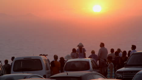 Santorini-Sonnenuntergang-Von-Einem-Parkplatz-Aus,-Während-Leute-Zuschauen