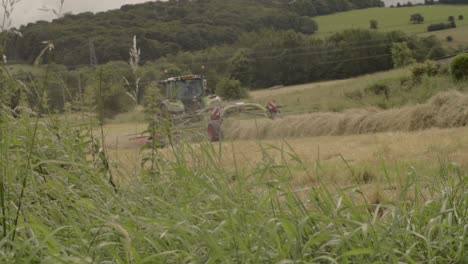 Tractor-Tirando-Del-Rastrillo-De-Heno-En-El-Campo