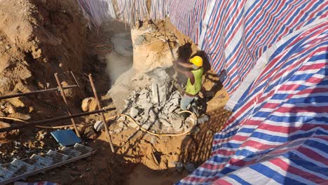 Ein-Bauarbeiter-Schneidet-Und-Bricht-Fundamentbohrpfähle-Mithilfe-Einer-Hackmethode-Auf-Der-Baustelle