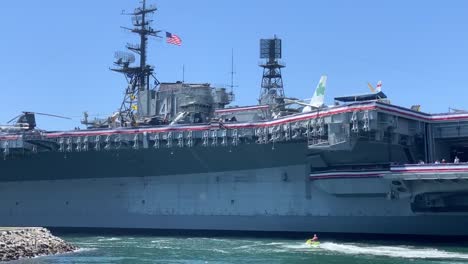 Dos-Motos-De-Agua-Que-Pasan-Por-El-Museo-Uss-Midway,-Un-Museo-Histórico-De-Portaaviones-Navales-De-Los-Estados-Unidos-Ubicado-En-El-Centro-De-San-Diego,-California-En-El-Muelle-De-La-Marina