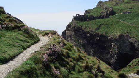 Tourist-Im-Urlaub-Zu-Fuß-Auf-Einer-Klippe-Entlang-Des-Pfades,-Der-Zu-Den-Ruinen-Von-Tintagel-Castle-In-Cornwall-Führt