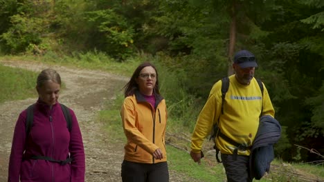 Medium-shot-of-three-people-walk-on-a-hiking-trail-at-Via-Transylvania,-Romania