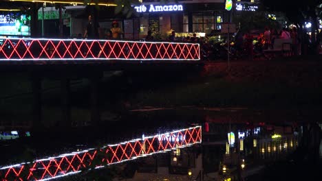 Gente-Caminando-Sobre-Un-Puente-Iluminado