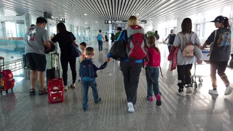 Xian,-China---Julio-De-2019:-Madre-Y-Sus-Hijos-Caminando-En-El-Pasillo-Del-Aeropuerto-Después-De-Llegar-En-Avión