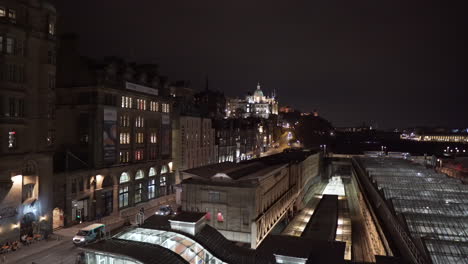 Schwenkaufnahme-Von-Edinburgh-Bei-Nacht-Von-Der-North-Bridge-Aus-Mit-Dem-Edinburgh-Royal-Hotel,-Dem-Bahnhof-Waverley,-Dem-Schloss-Und-Dem-Scott-Monument