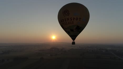 Sunrise-of-a-Hot-Air-Balloon-on-a-Misty-Morning-Over-Amish-Farmlands-as-Seen-by-a-Drone