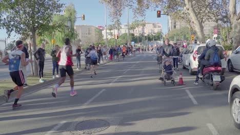 Los-Fanáticos-Ven-A-Los-Concursantes-Del-Maratón-Corriendo-Por-La-Carretera,-Maratón-De-Zurich-Malaga