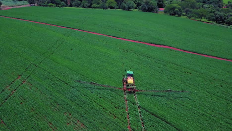 Imagen-Aérea-De-Tractor-Rociando-Suelo-Y-Cultivo-Joven-En-Primavera-En-El-Campo