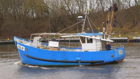 Blue-Fishing-Boat-sails-into-port-in-Kolobrzeg,-Poland