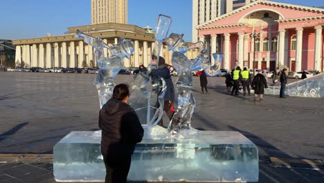 Mutter-Sieht-Zu,-Wie-Ihr-Sohn-Auf-Einer-Eisskulptur-Mit-Musikmotiv-Spielt