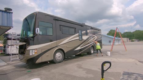 Woman-scrubbing-a-vehicle-while-working-at-Detail-Depot,-RV-washing-small-business