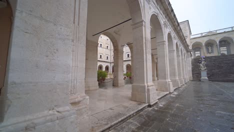 Mujer-Turista-Caminando-Sola-En-Un-Patio-Vacío-Y-Desolado-En-La-Abadía-De-Montecassino,-Italia,-Pandemia-De-Covid-19,-Estática