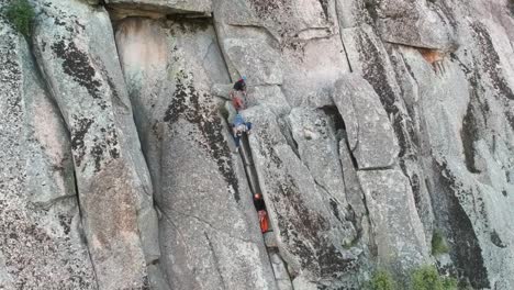 Toma-Aérea-Acercándose-A-Algunos-Escaladores-En-Una-Pared-De-Granito