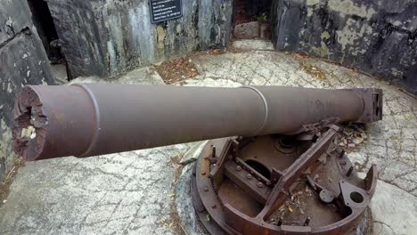 Anti-aircraft-gun-from-the-World-War-II-at-Cannon-Fort-on-the-island-jungle,-Aerial-orbit-reveal-shot