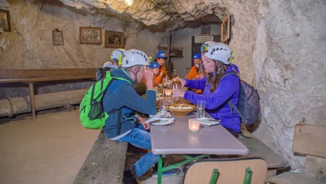 Group-of-young-tourists-enjoy-local-cold-cuts-in-a-cave