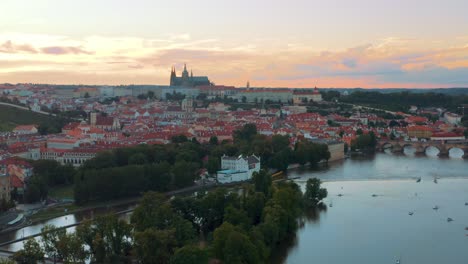 Vista-Aérea-Del-Centro-De-La-Ciudad-Vieja-De-Praga-Durante-La-Puesta-De-Sol-Naranja-Dorada-Con-El-Castillo-De-Praga-Y-El-Río-Vltava