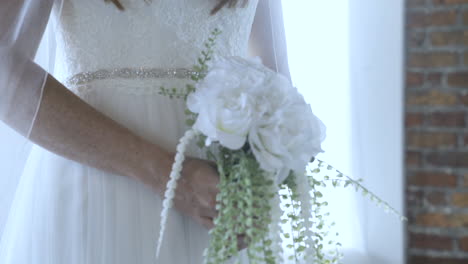 Novia-Sosteniendo-Un-Ramo-Con-Un-Vestido-Blanco-Preparado-Para-El-Día-De-La-Boda-Por-Delante