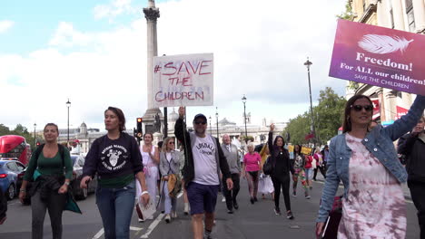 A-QAnon-Save-Our-Children-protestor-carries-a-placard-that-says,-“Children-not-for-sale,-defund-BBC-on-a-march-promoting-international-pedophile-ring-and-Coronavirus-conspiracy-theories