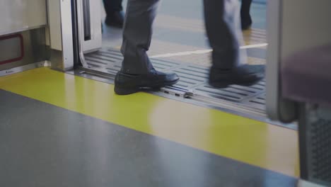 Legs-Of-Passengers-Walking-Out-And-Getting-Into-The-Train-In-Tokyo,-Japan