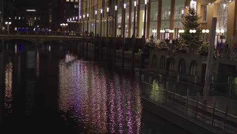 Christmas-tree-and-lights-and-crowds-along-a-canal-in-Hamburg,-Germany,-in-Dec-2019