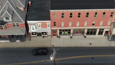 Business-storefronts-line-the-busy-street-in-city-as-traffic-passes-by