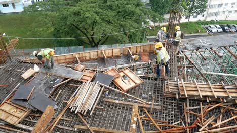 Trabajadores-De-La-Construcción-Que-Fabrican-Barras-De-Refuerzo-De-Acero---Encofrado-De-Madera-En-El-Sitio-De-Construcción