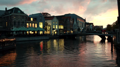 Imágenes-Coloridas-De-Lapso-De-Tiempo-De-Canales-Fluviales,-Gente-Caminando-Sobre-El-Puente-Y-Colorida-Puesta-De-Sol-En-El-Fondo-En-Leiden