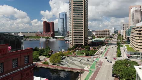 Beautiful-rising-aerial-reveals-Baltimore-Inner-Harbor-and-financial-district-on-summer-day,-traffic-on-Pratt-Street,-clipper-ships-in-harbor