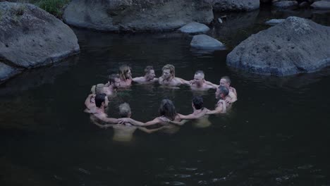 Un-Hombre-Comparte-Felizmente-La-Vida,-La-Experiencia-Y-Los-Aprendizajes-De-Su-Equipo-Mientras-Está-Acurrucado-En-El-Agua---Rocky-Creek-En-Mount-Byron,-Queensland,-Australia