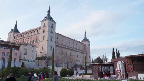 Menschen,-Die-Bei-Schönem-Wetter-Durch-Das-Ikonische-Gebäude-Alcazar-De-Toledo-In-Toledo,-Spanien,-Schlendern-–-Totalaufnahme