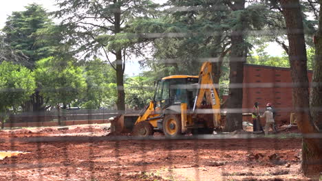 Trabajos-De-Construcción-En-El-Recinto-Del-Zoológico-A-Través-De-La-Cerca,-Toma-Panorámica-Lenta-De-Izquierda-A-Derecha