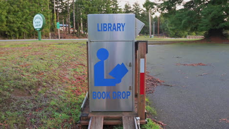 Buzón-De-Entrega-De-Libros-De-Acero-Inoxidable-Al-Borde-De-La-Carretera-Para-Una-Biblioteca-En-Langlois,-Oregon---Tilt-up