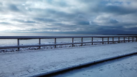 Wide-shot-of-a-winter-jogger-passing-through-frame-on-the-Beaches-boardwalk