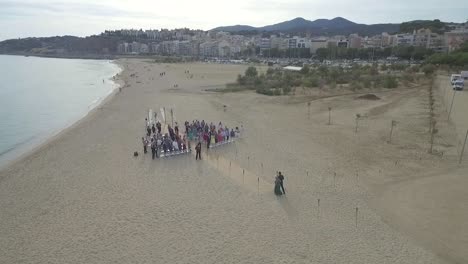 Pareja-Caminando-Por-El-Pasillo-En-La-Ceremonia-De-Boda-En-La-Playa,-Dando-Vueltas-Aéreas