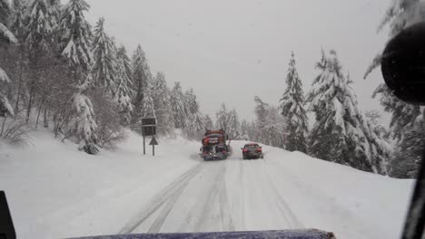 Snowplow-overtakes-a-car-stuck-on-snowy-road