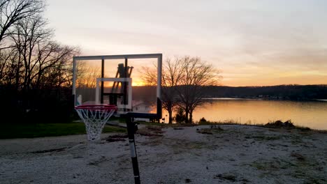 Aro-De-Baloncesto-Al-Aire-Libre-Spalding-Con-Hermosa-Puesta-De-Sol-En-El-Lago-En-El-Fondo