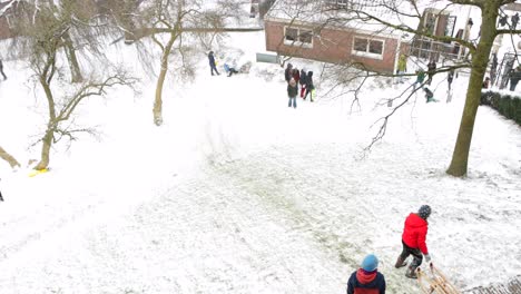 Children-sledding-on-a-snowy-Burcht-in-Leiden,-the-Netherlands-during-the-pandemic